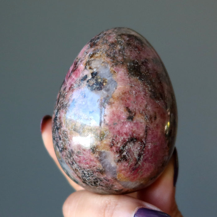 rhodonite egg in hand