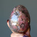 rhodonite egg in hand