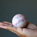 peruvian rhodonite sphere in palm