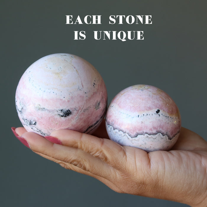 two peruvian rhodonite spheres in hand