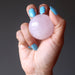 hand holding pink rose quartz crystal ball