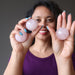 sheila of satin crystals holding up three rose quartz spheres