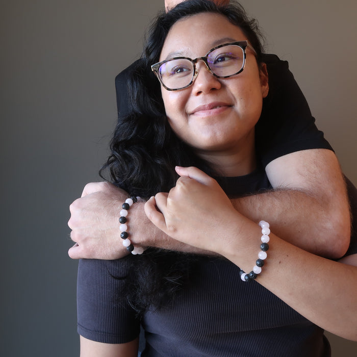 man embracing woman as they wear matching rose quartz lava bracelets 