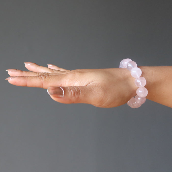 hand wearing clear pink rose quartz round beaded stretch bracelet