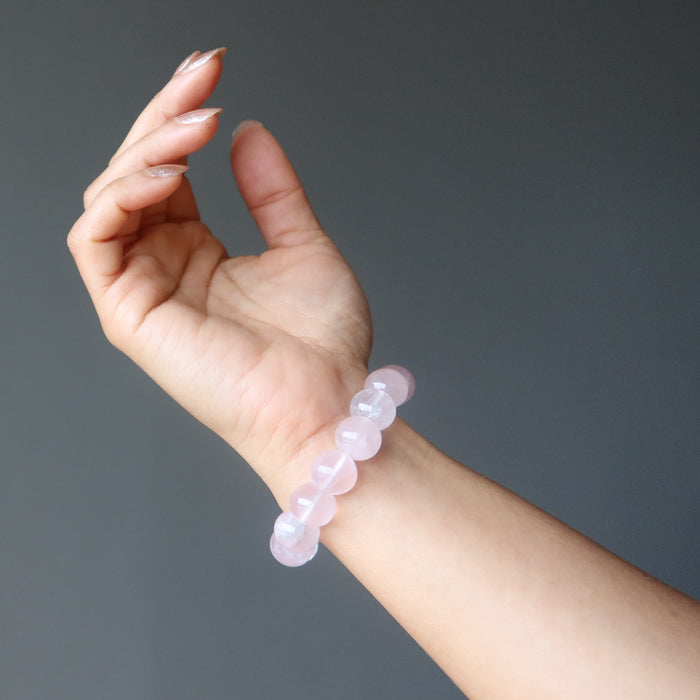 hand wearing clear pink rose quartz round beaded stretch bracelet