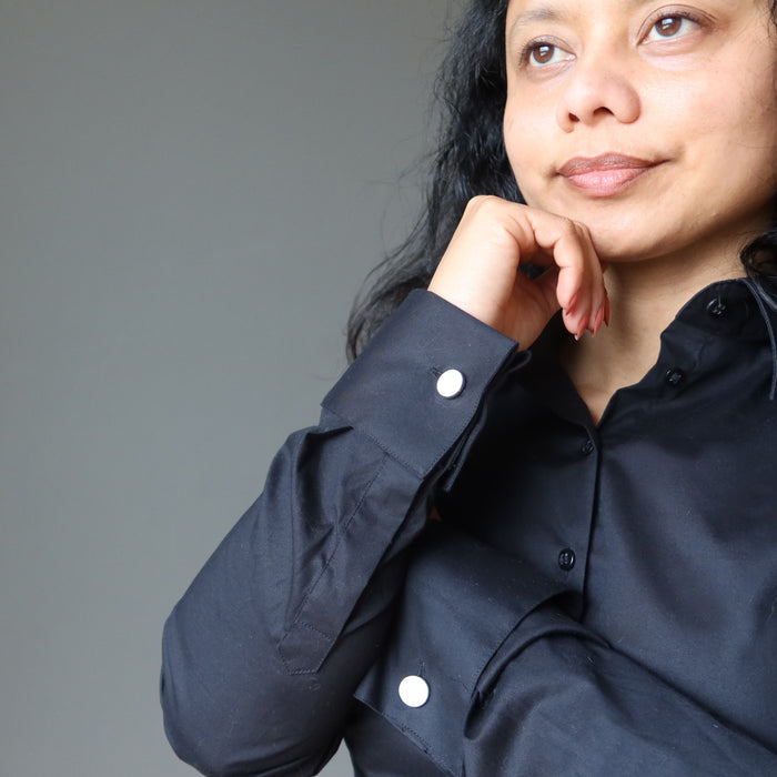 woman wearing black french cuffs secured with rose quartz cufflinks