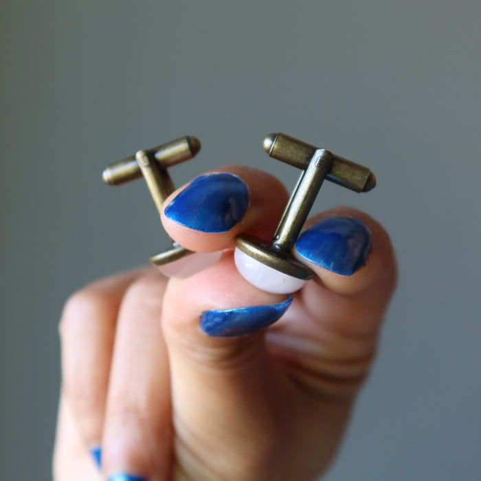 hand holding rose quartz antique bronze cufflinks showing bullet clasps