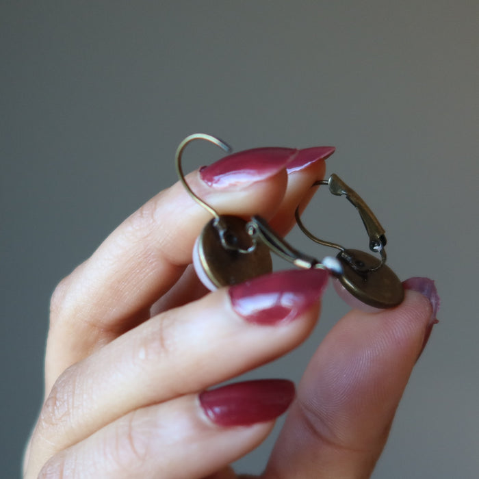 hands holding rose quartz earrings showing open and closed leverbacks