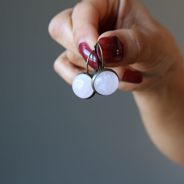 hand holding rose quartz leverback earrings