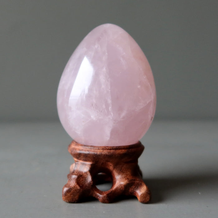 pink rose quartz egg on display stand
