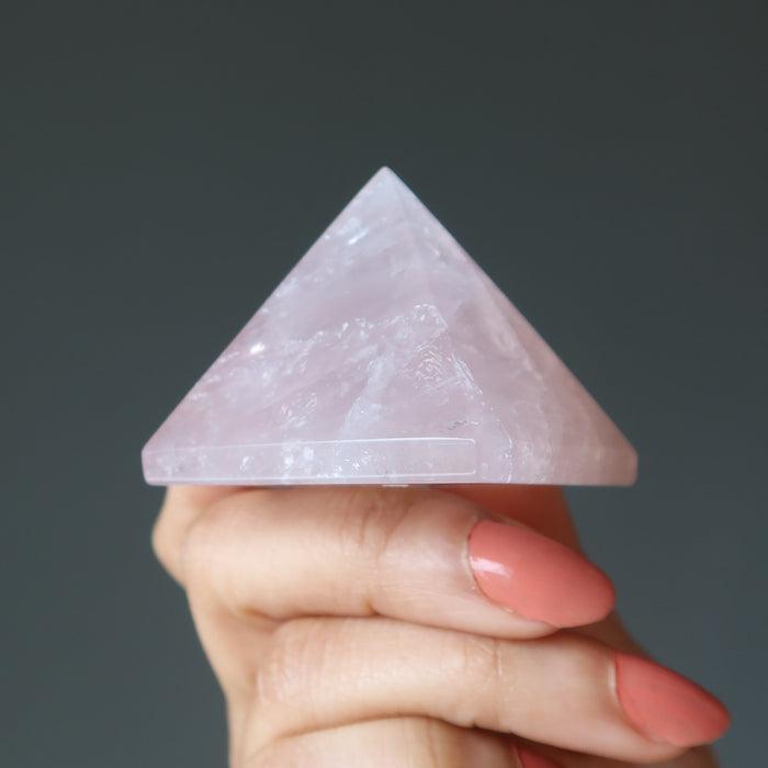 hand holding pink rose quartz pyramid