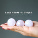 three rose quartz spheres in hand