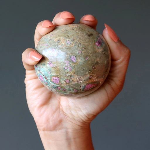 ruby fuchsite crystal ball in hand