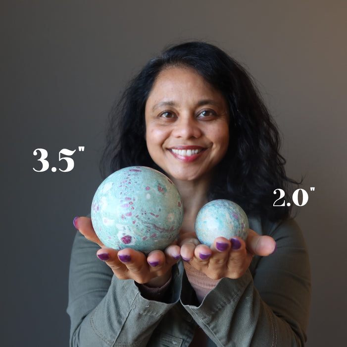 sheila of satin crystals holding two hand holding ruby fuchsite spheres