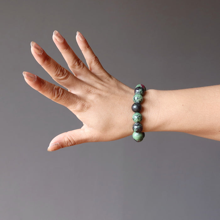 hand wearing ruby zoisite round stretch bracelet
