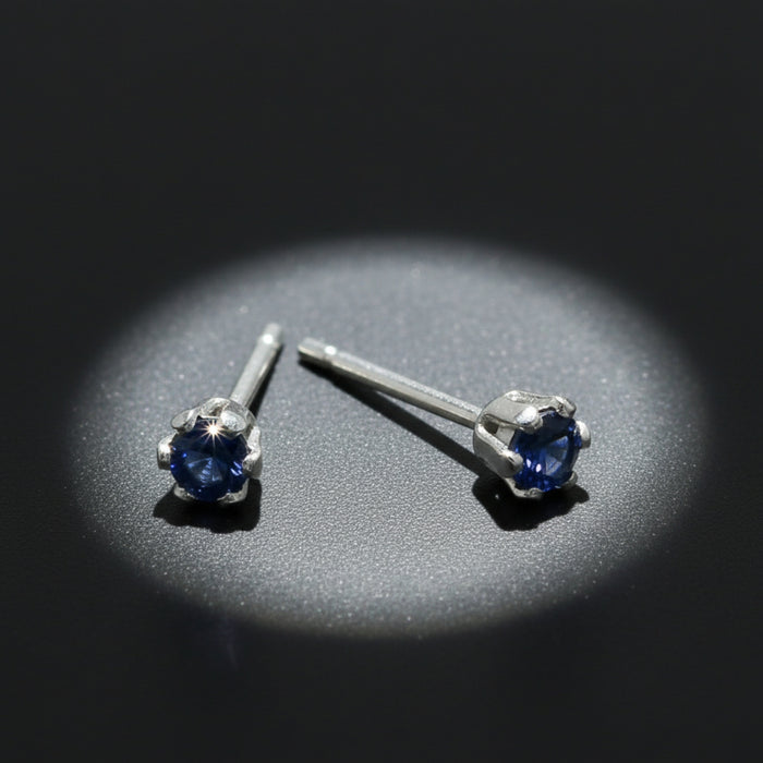 blue sapphire faceted earrings in a spotlight
