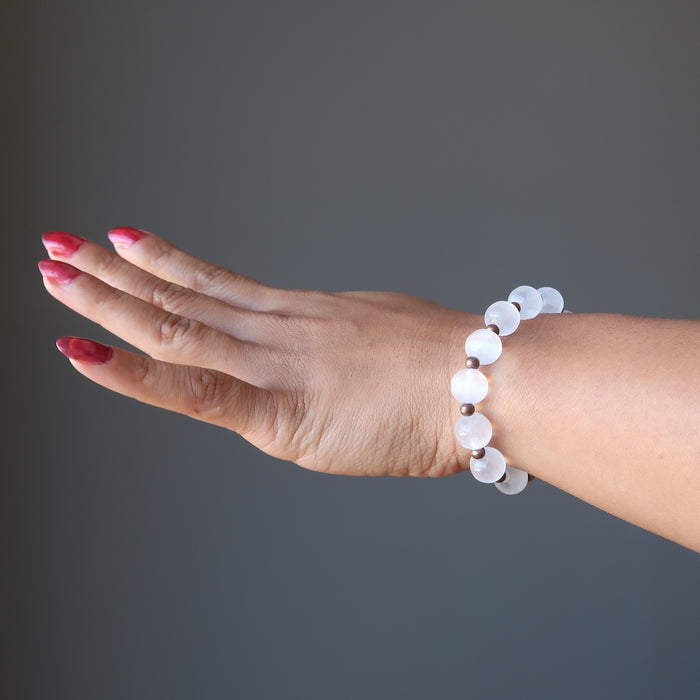 hand wearing white selenite and antique beads stretch bracelet