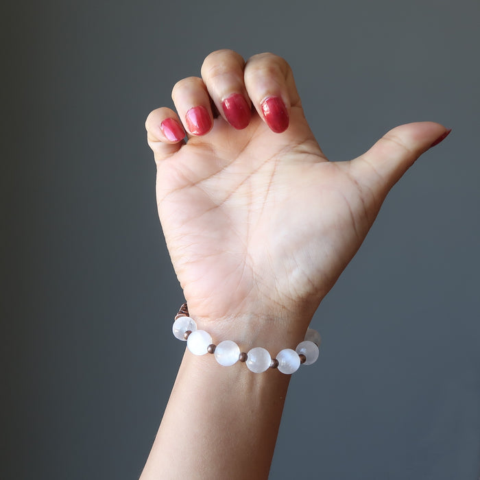 hand wearing white selenite and antique beads stretch bracelet