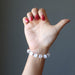 hand wearing white selenite and antique beads stretch bracelet