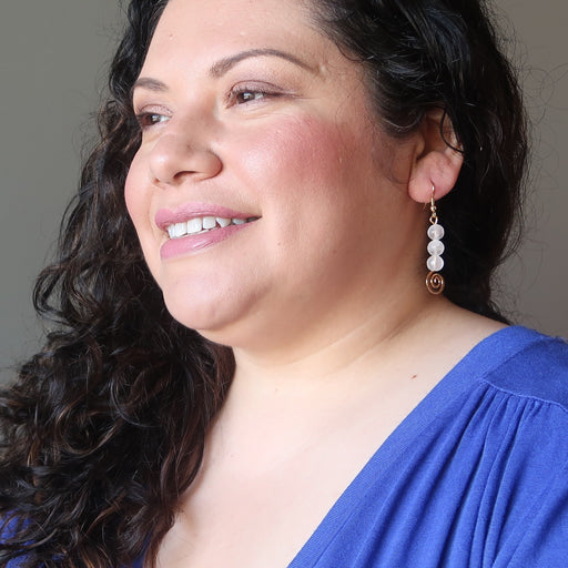 sotera of satin crystals wearing white selenite gold spiral dangle earrings