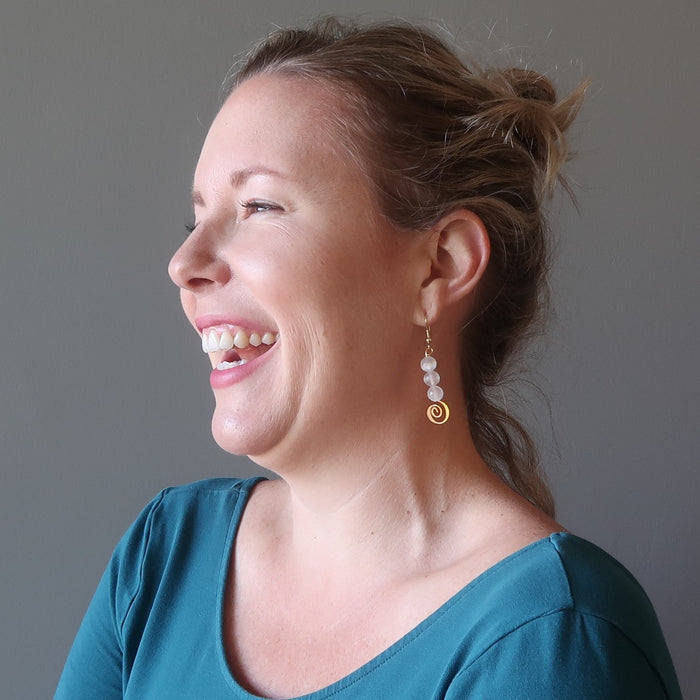 liz of satin crystals wearing white selenite gold spiral dangle earring