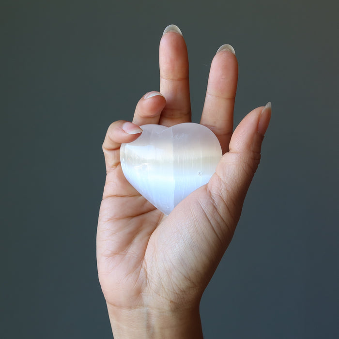 hand holding a selenite heart