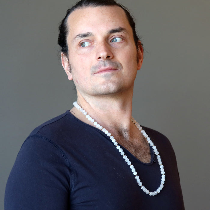 man wearing white selenite necklace