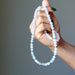 hand holding white selenite necklace