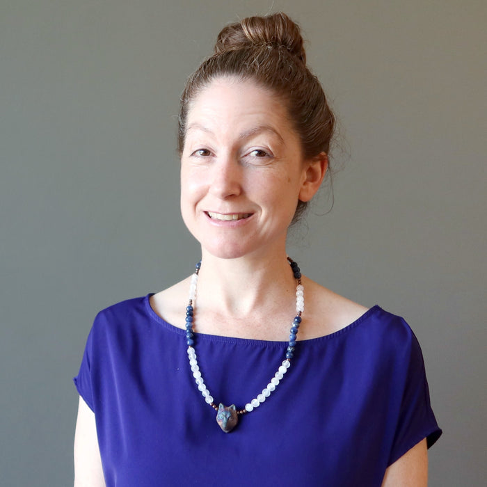 female wearing selenite sodalite wolf necklace