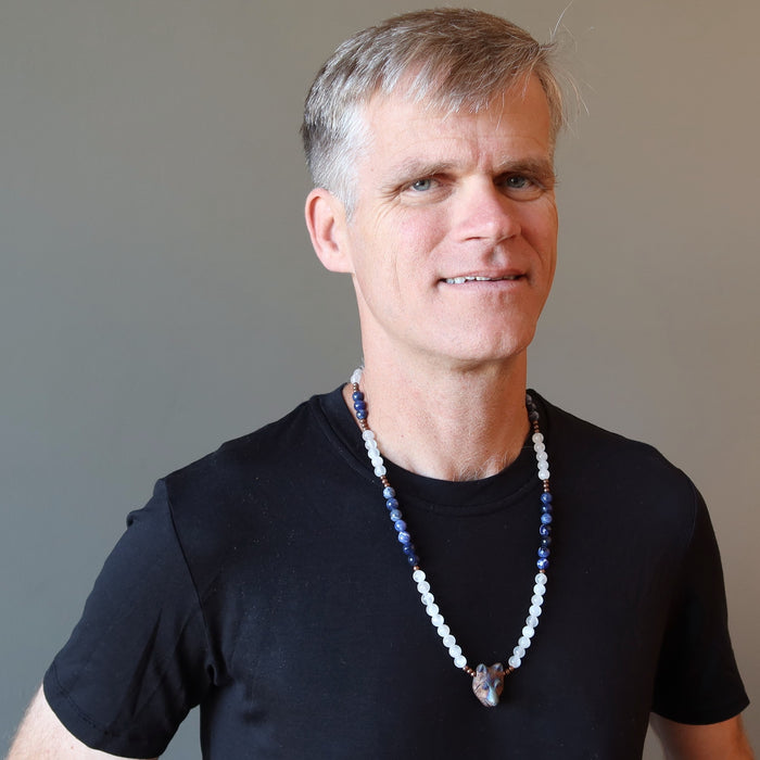 male wearing selenite sodalite wolf necklace