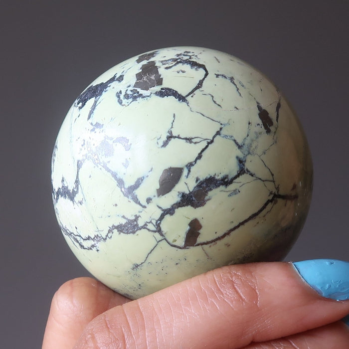 hand holding a serpentine sphere