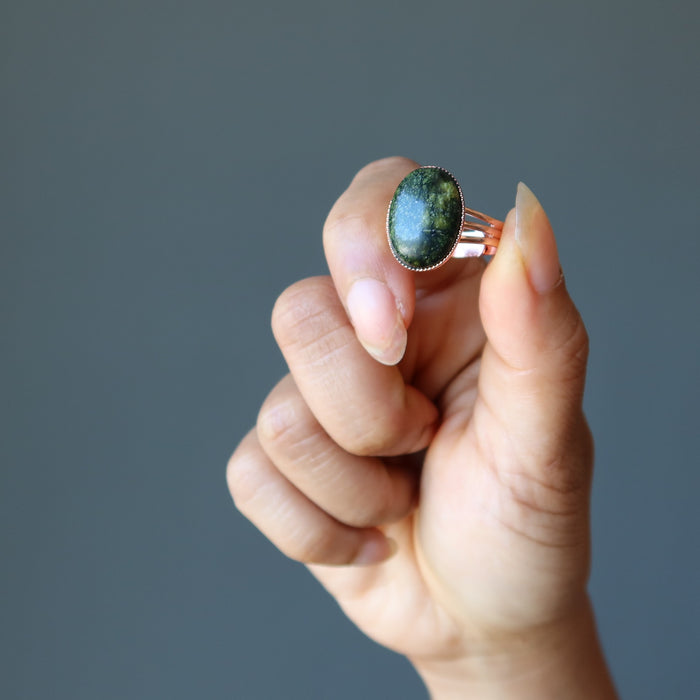 hand holding serpentine copper ring