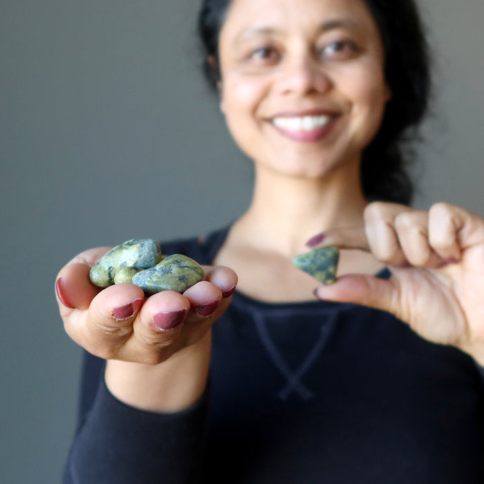 Sheila picking one of many Serpentine Tumbled Stones from the other hand