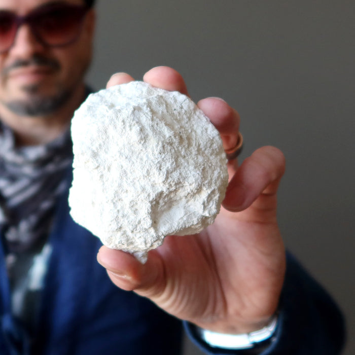 male model holding clam fossil 