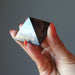 hand holding black shungite stone pyramid