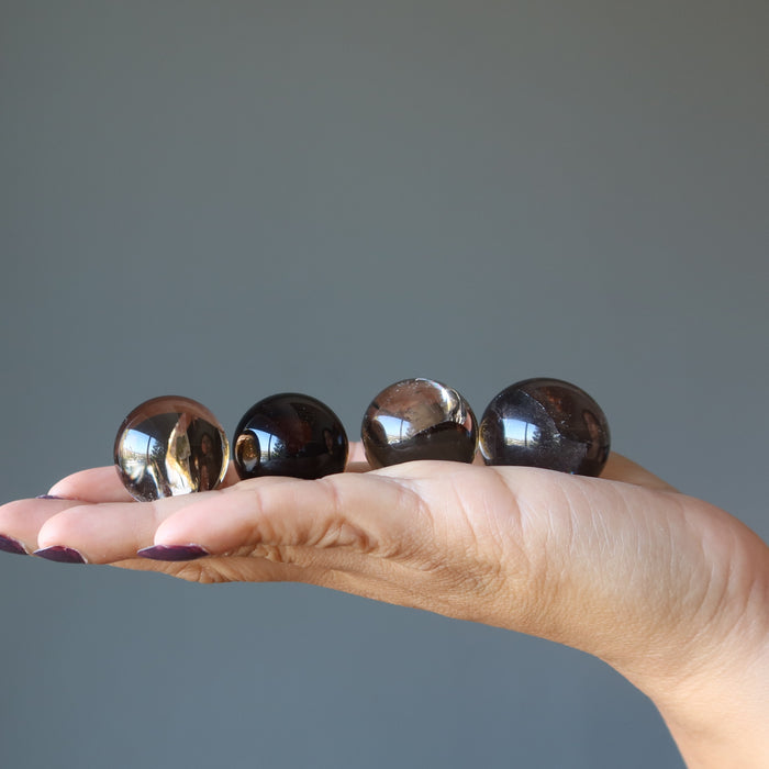 rainbow smoky quartz spheres in hand