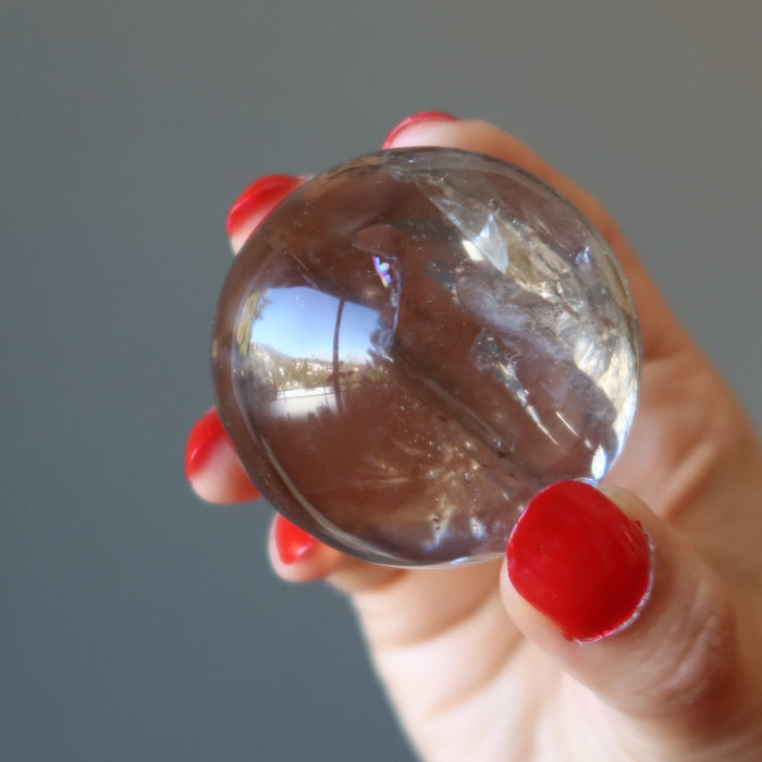 hand holding Smoky Quartz Sphere