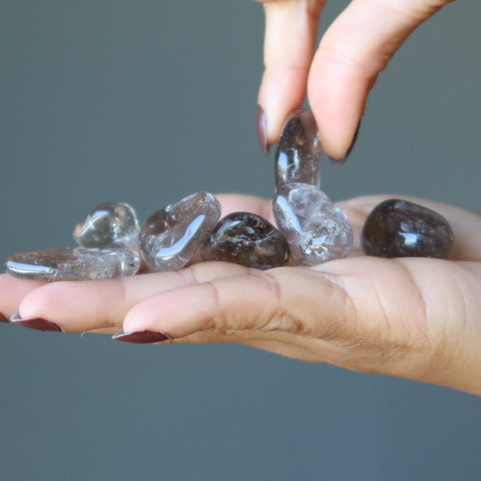 picking one of Smoky Quartz Tumbled Stones up from the palm