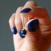 hand holding sodalite earring
