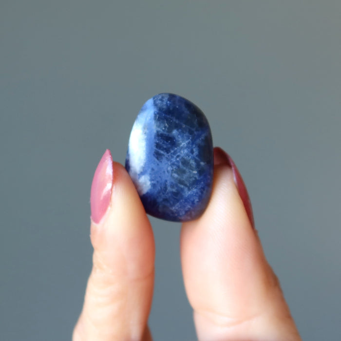 finger tips raise up a tumbled sodalite