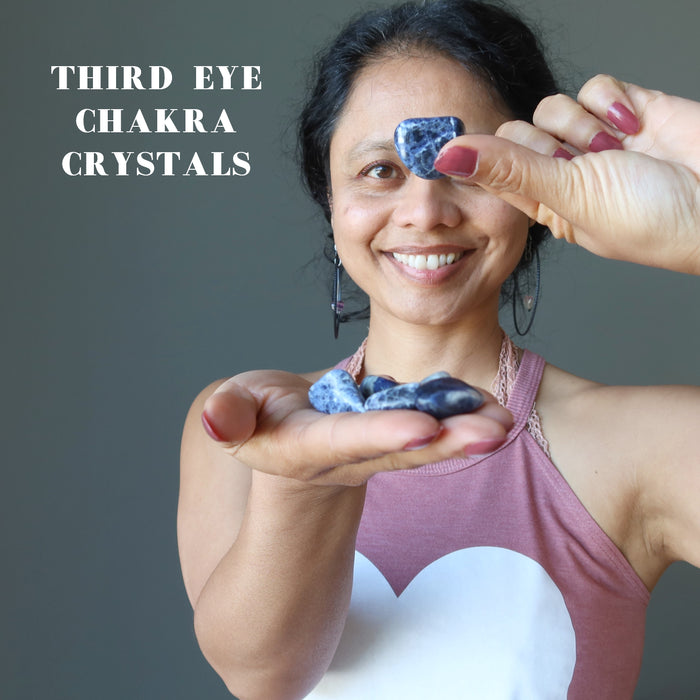 Sheila of satin crystals holding Sodalite Tumbled Stones on her right palm and raise up soldalite tumbled stone with finger tips of left hand