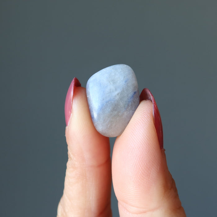 finger tips raising up Sodalite tumble stone