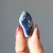 finger tips raise up a tumbled sodalite