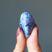 finger tips raise up a tumbled sodalite