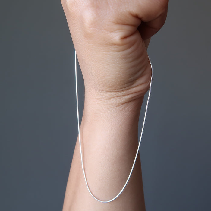 hand holding sterling silver snake chain necklace