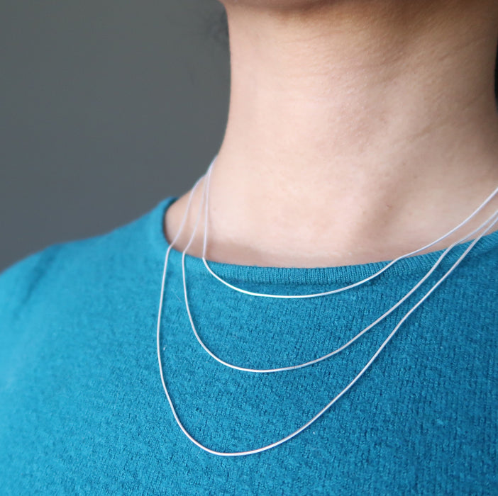 sheila of satin crystals wearing 3 sizes of sterling silver snake chain necklace