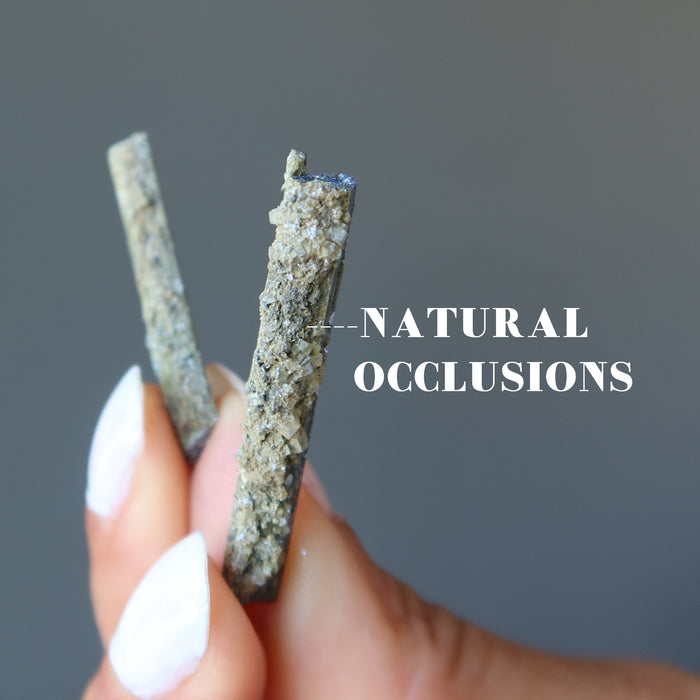 holding two holding raw Stibnite wands