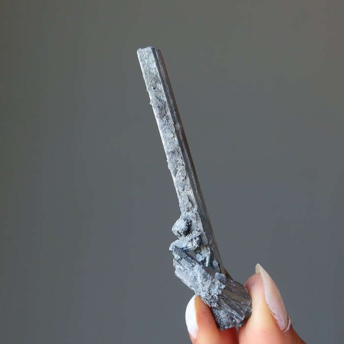 holding raw Stibnite wand 