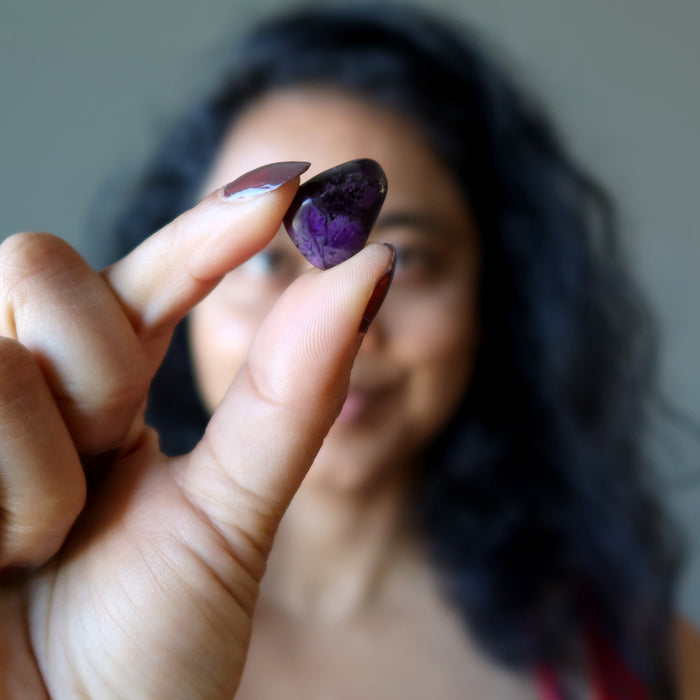 fingers holding Sugilite Polished Stone