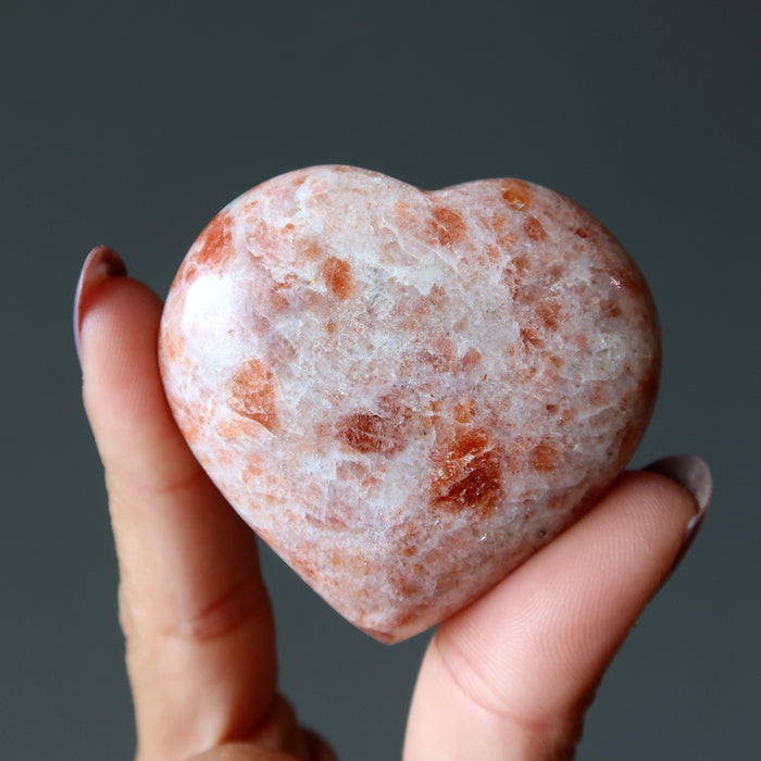 finger tips holding Sunstone Heart 
